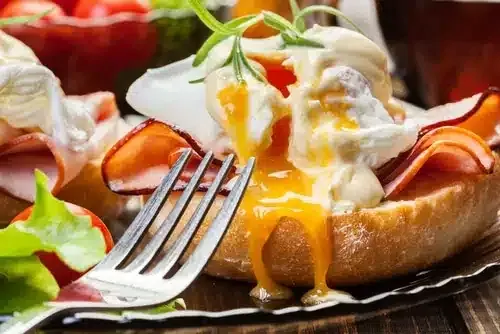 Eggs Benedict yrtti-hollandaise-kastikkeella